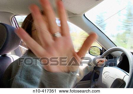 Young woman, wearing glasses, driving her automobile and sticking out the palm of her hand. View Large Photo Image Stock Image - Young woman, wearing glasses, driving her automobile and sticking out the palm of her hand.. Fotosearch