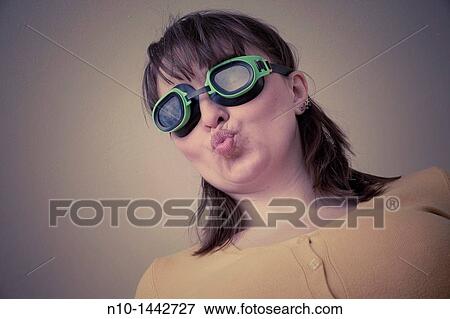 Stock Photo - Young woman wearing goggles. Fotosearch