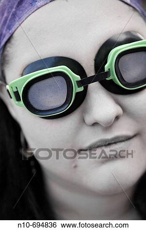 Stock Photograph - Young woman wearing green goggles. Fotosearch