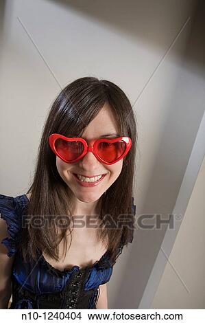 Young woman wearing heart shaped glasses View Large Photo Image Picture - Young woman wearing heart shaped glasses. Fotosearch