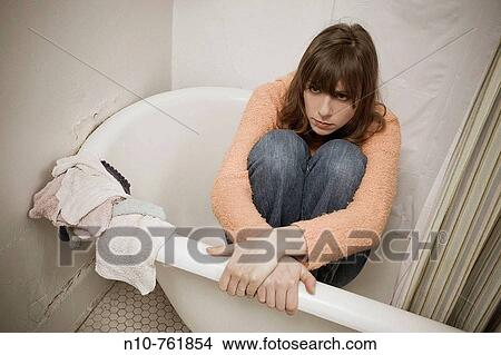 Young woman, wearing her street clothes, sitting in her bathtub View Large Photo Image Picture - Young woman, wearing her street clothes, sitting in her bathtub. Fotosearch