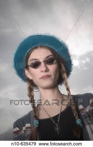 Young woman, wearing pigtails, sunglasses, and a hat, posing View Large Photo Image Stock Photo - Young woman, wearing pigtails, sunglasses, and a hat, posing. Fotosearch