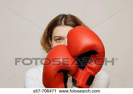 Stock Image - Young woman wearing red boxing gloves. Fotosearch