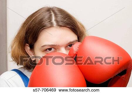 Stock Photo - Young woman wearing red boxing gloves. Fotosearch