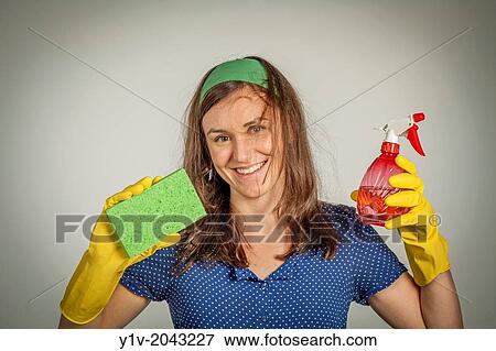Stock Photo - Young woman wearing rubber gloves and holding cleaning supplies.. Fotosearch