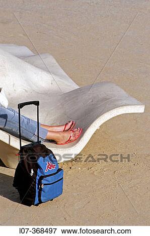 Stock Photo - Young woman wearing sandals resting in park with backpack. Barcelona. Spain. Fotosearch