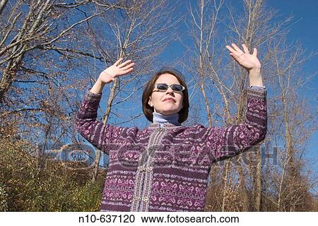 Stock Image - Young woman, wearing sunglasses, posing. Fotosearch