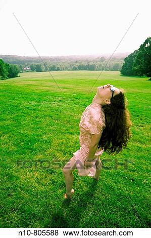 Young woman, wearing sunglasses, posing at a park. View Large Photo Image Stock Photo - Young woman, wearing sunglasses, posing at a park.. Fotosearch