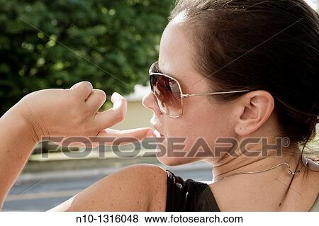 Stock Photo - Young woman wearing sunglasses. Fotosearch