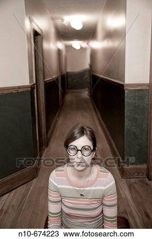 Young woman, wearing thick glasses, posing in the hallway of her apartment building. View Large Photo Image Stock Image - Young woman, wearing thick glasses, posing in the hallway of her apartment building.. Fotosearch