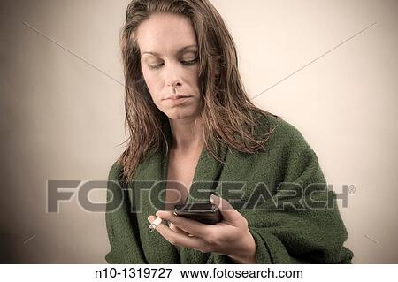 Young woman with a cigarette and cell phone View Large Photo Image Stock Photo - Young woman with a cigarette and cell phone. Fotosearch