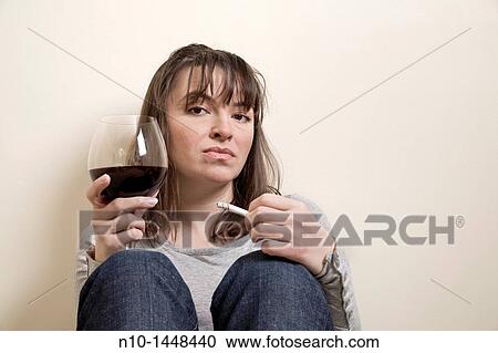 Young woman with a cigarette and glass of wine View Large Photo Image Stock Image - Young woman with a cigarette and glass of wine. Fotosearch