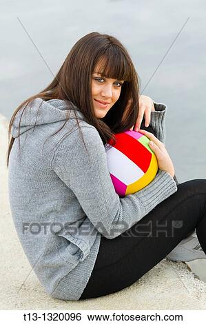 Stock Photograph - Young woman with a colorful ball. Fotosearch