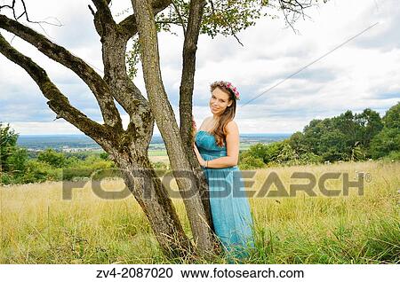 Young woman with a floral wreath in her hair outdoors, Germany. View Large Photo Image Stock Image - Young woman with a floral wreath in her hair outdoors, Germany.. Fotosearch