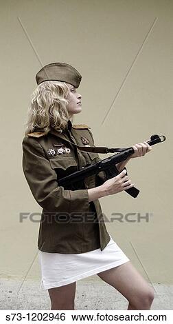 Stock Photograph - Young woman with a Kalashnikov and wearing Russian soldier's clothes. Fotosearch