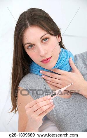 Young woman with a sore throat and a blue scarf holding a medical thermometer View Large Photo Image Stock Photo - Young woman with a sore throat and a blue scarf holding a medical thermometer. Fotosearch