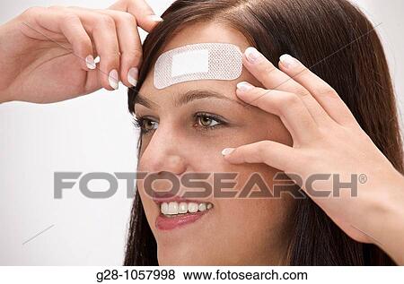 young woman with adhesive sticking on her forehead for a slight wound View Large Photo Image Stock Photo - young woman with adhesive sticking on her forehead for a slight wound. Fotosearch