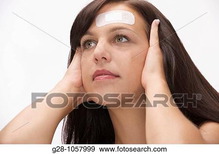 young woman with adhesive sticking on her forehead for a slight wound View Large Photo Image Stock Photo - young woman with adhesive sticking on her forehead for a slight wound. Fotosearch
