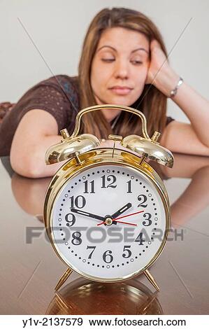 Stock Photo - Young woman with an alarm clock.. Fotosearch