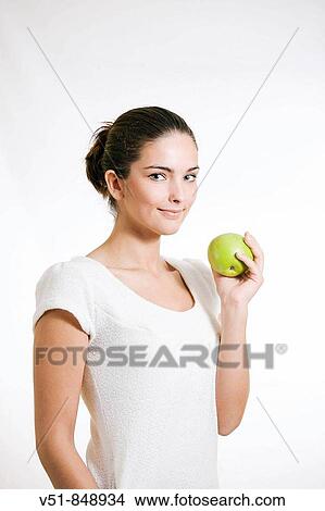 Picture - Young woman with an apple. Fotosearch