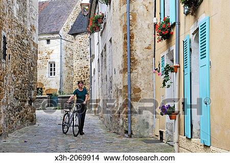 young woman with bicycle, Toussaint street, Mortagne-au-Perche, Regional Natural Park of Perche, Orne department, Lower Normandy region, France, Western Europe. View Large Photo Image Picture - young woman with bicycle, Toussaint street, Mortagne-au-Perche, Regional Natural Park of Perche, Orne department, Lower Normandy region, France, Western Europe.. Fotosearch