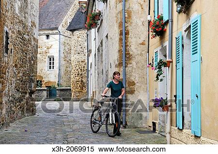 young woman with bicycle, Toussaint street, Mortagne-au-Perche, Regional Natural Park of Perche, Orne department, Lower Normandy region, France, Western Europe. View Large Photo Image Stock Photography - young woman with bicycle, Toussaint street, Mortagne-au-Perche, Regional Natural Park of Perche, Orne department, Lower Normandy region, France, Western Europe.. Fotosearch