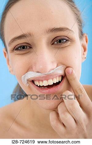 Young woman with cream on face, laughing, close-up View Large Photo Image Stock Photo - Young woman with cream on face, laughing, close-up. Fotosearch