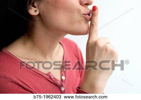 Young woman with finger on lips in silence View Large Photo Image Stock Image - Young woman with finger on lips in silence. Fotosearch