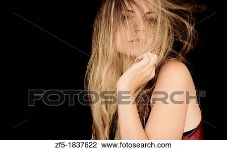 Stock Image - Young woman with hair across her face. Fotosearch