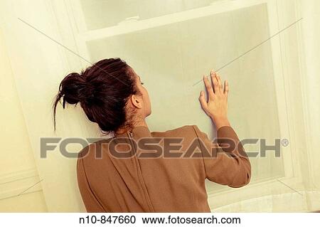Young woman with her hand on a window. View Large Photo Image Stock Image - Young woman with her hand on a window.. Fotosearch