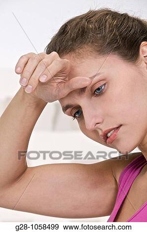 young woman with her hand on her forehead suffering from a headache View Large Photo Image Stock Photo - young woman with her hand on her forehead suffering from a headache. Fotosearch