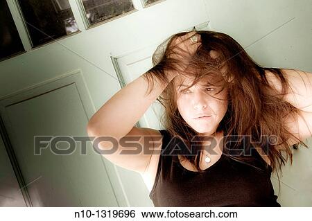 Young woman with her hands in her hair View Large Photo Image Stock Photograph - Young woman with her hands in her hair. Fotosearch