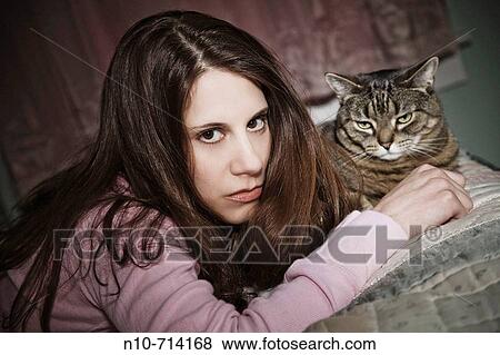 Young woman, with her pet cat, lying on her bed. View Large Photo Image Stock Photo - Young woman, with her pet cat, lying on her bed.. Fotosearch