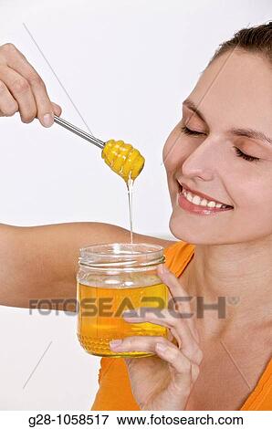 Stock Photo - young woman with jar of organic honey. Fotosearch