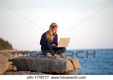 Young woman with laptop computer on rocky beach Acadia National Park, Schoodic Peninsula, Maine, USA View Large Photo Image Stock Photo - Young woman with laptop computer on rocky beach Acadia National Park, Schoodic Peninsula, Maine, USA. Fotosearch