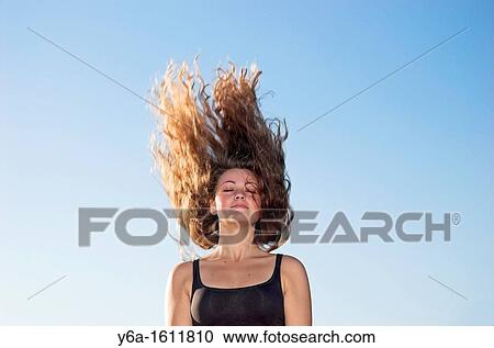 Young woman with long hair tossing head back View Large Photo Image Stock Image - Young woman with long hair tossing head back. Fotosearch