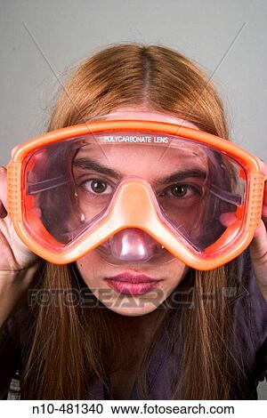 Young woman, with long red hair, looking through a pair of swimming goggles View Large Photo Image Stock Image - Young woman, with long red hair, looking through a pair of swimming goggles. Fotosearch