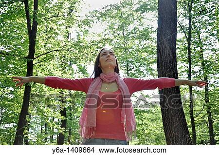 Young woman with outstretched arms in woods View Large Photo Image Picture - Young woman with outstretched arms in woods. Fotosearch
