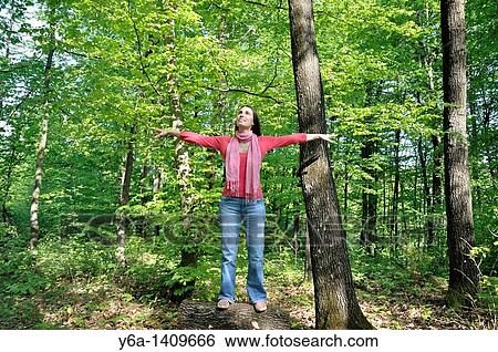 Young woman with outstretched arms in woods View Large Photo Image Stock Photograph - Young woman with outstretched arms in woods. Fotosearch