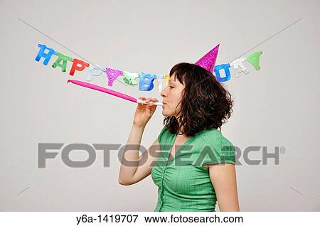 Young woman with party horn blower View Large Photo Image Stock Photo - Young woman with party horn blower. Fotosearch