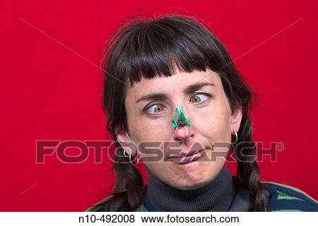 Young woman with pigtails and a clothespin clamped to her nose View Large Photo Image Stock Photo - Young woman with pigtails and a clothespin clamped to her nose. Fotosearch