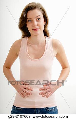 Young woman with pink top and blue jeans with her hands on her hips, for pain, stomach pain, or periods pain, or slimming View Large Photo Image Stock Photo - Young woman with pink top and blue jeans with her hands on her hips, for pain, stomach pain, or periods pain, or slimming. Fotosearch
