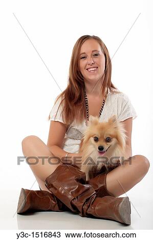 Stock Image - Young woman with pomeranian dog. Fotosearch