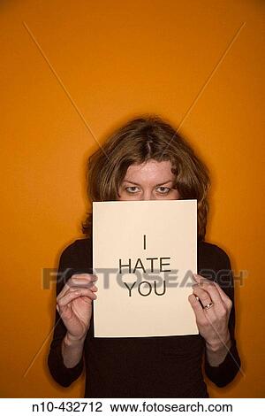 Young woman, with red hair, holding up a sign stating I hate you"" View Large Photo Image Stock Image - Young woman, with red hair, holding up a sign stating I hate you"". Fotosearch
