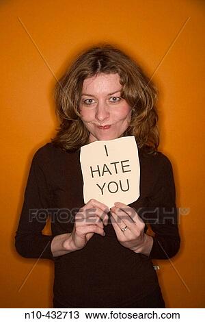 Young woman, with red hair, holding up a sign stating I hate you"" View Large Photo Image Stock Image - Young woman, with red hair, holding up a sign stating I hate you"". Fotosearch
