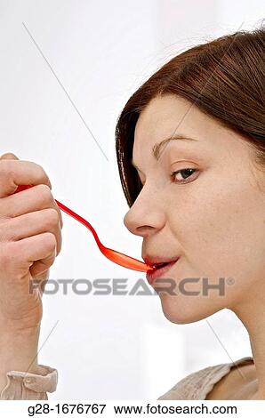 Stock Photo - young woman with red plastic spoon. Fotosearch