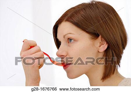 young woman with red plastic spoon View Large Photo Image Stock Photograph - young woman with red plastic spoon. Fotosearch