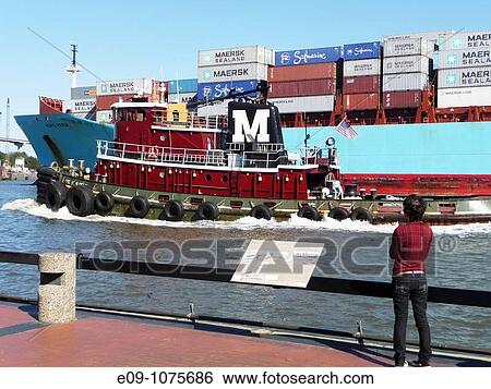 young woman with short hair, casual clothes, standing on riverfront walk at Savannah River, Savannah, Georgia, watching tugboat and Maersk Line carrier ship pass by View Large Photo Image Stock Photograph - young woman with short hair, casual clothes, standing on riverfront walk at Savannah River, Savannah, Georgia, watching tugboat and Maersk Line carrier ship pass by. Fotosearch