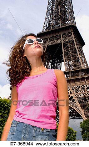 Picture - Young woman with white sunglasses in front of Eiffel Tower. Paris. France. Fotosearch