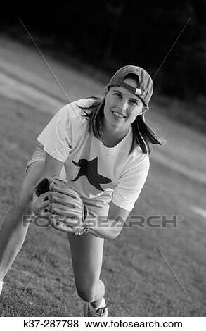 Stock Photo - Young woman with winning smile and star quality playing in baseball game. Fotosearch